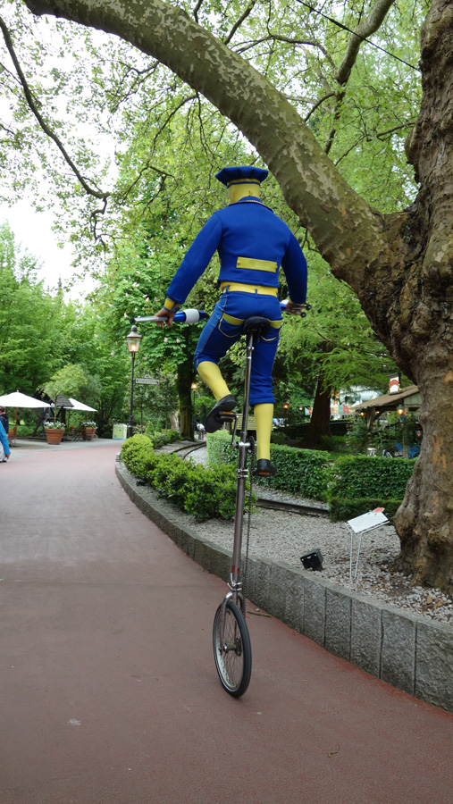 клоун на велосипеде в парке развлечений